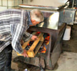 Jim Myers feeding wood into sugar boiler_maple syrup_edit